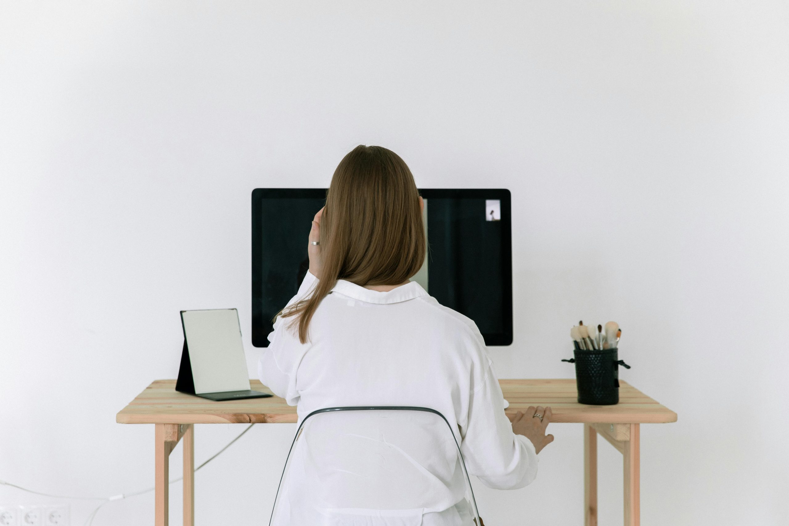 Lady sits at ergonomic desk with raised screen