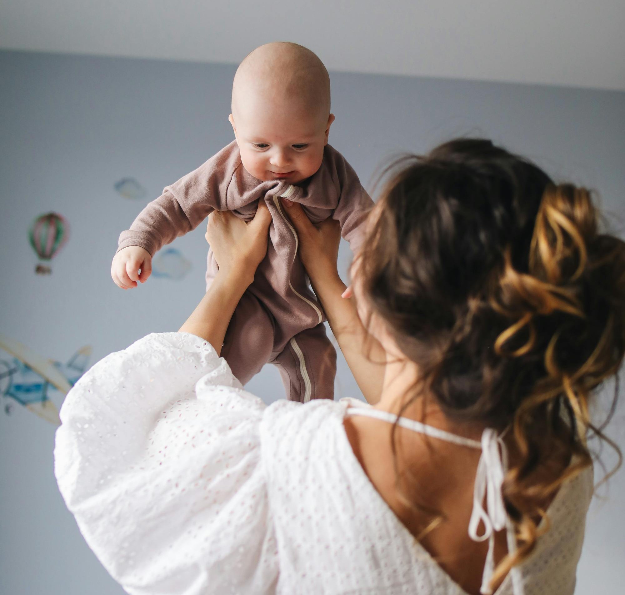 Lady lifts happy baby in the air after cranial osteopathy craniosacral therapy kent folkestone faversham